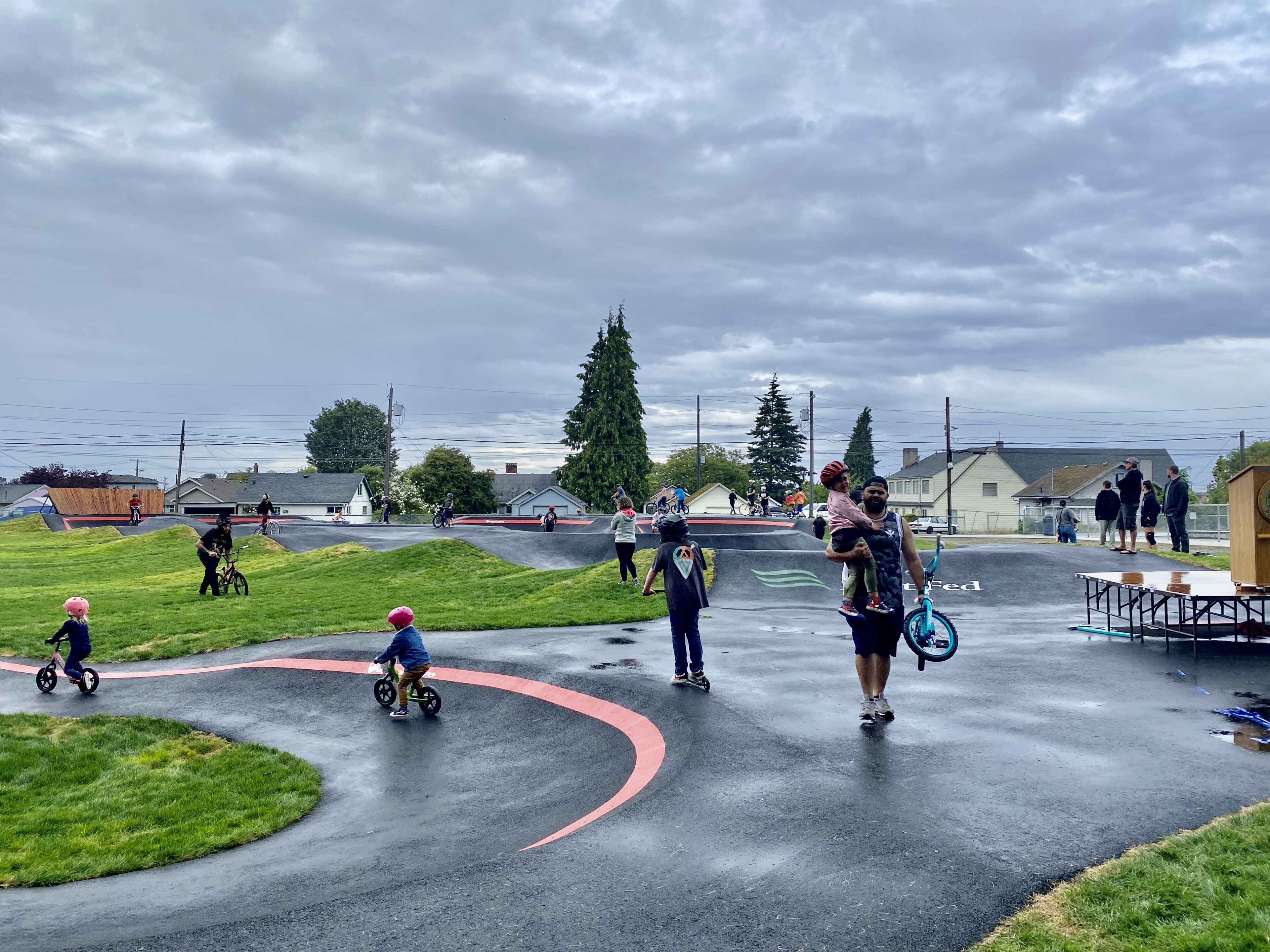 Children riding balance bikes at outdoor pump track