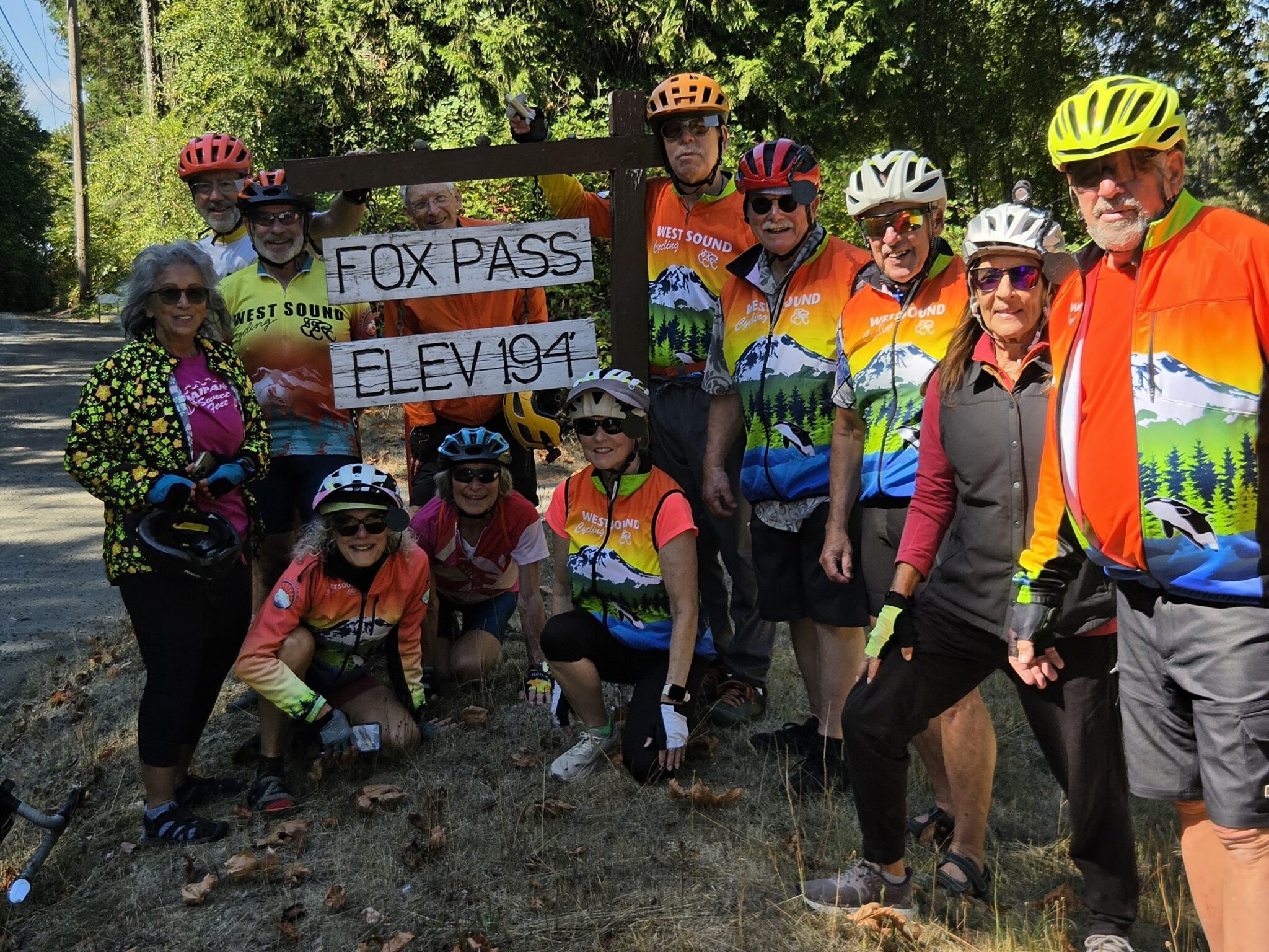 Group of cyclists at Fox Pass elevation sign