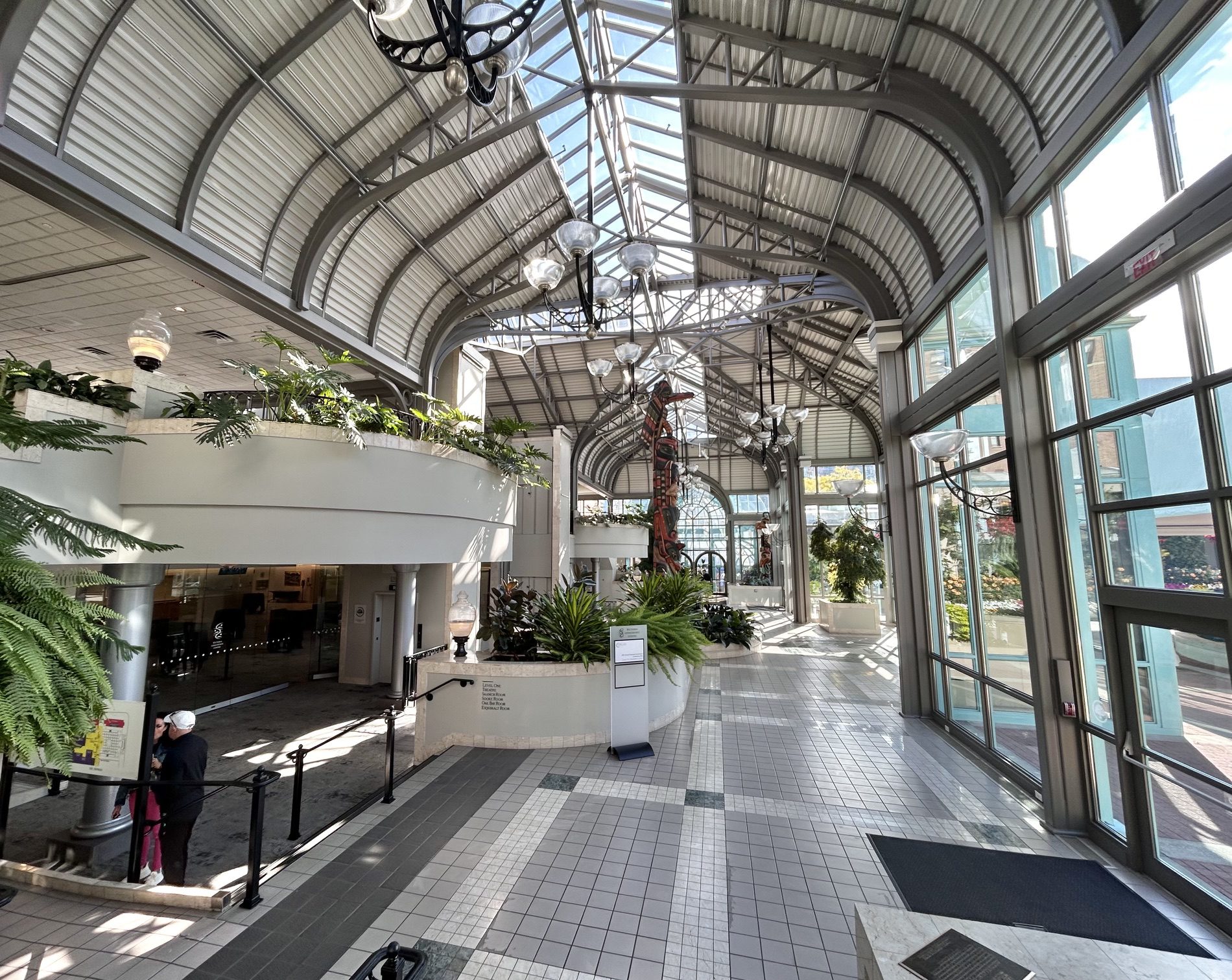 Sunlit glass-roofed atrium with plants